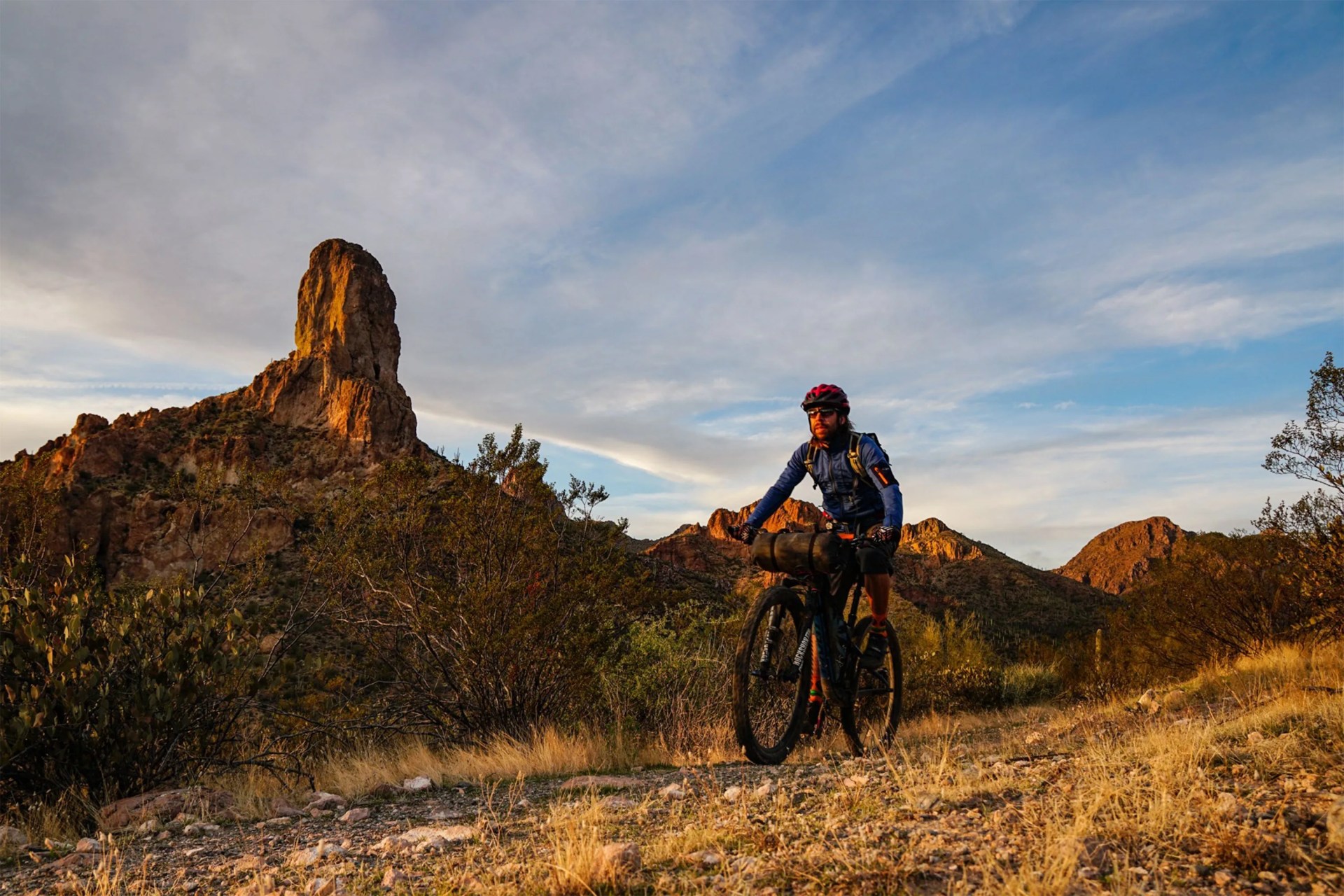 man riding a bike through the desert