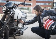 portrait of bearded man looking at a motorcycle
