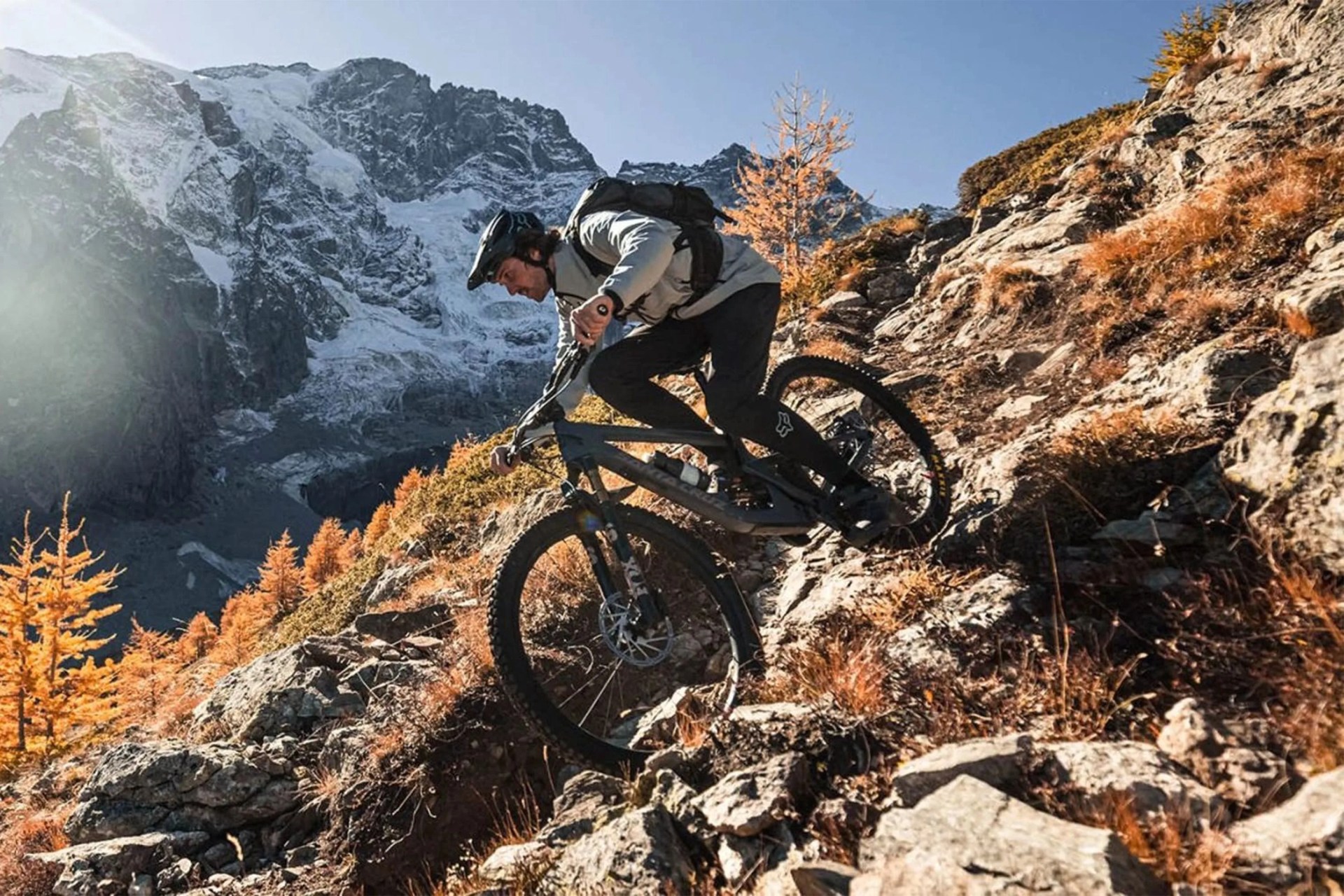 man riding a bike down a rocky mountain