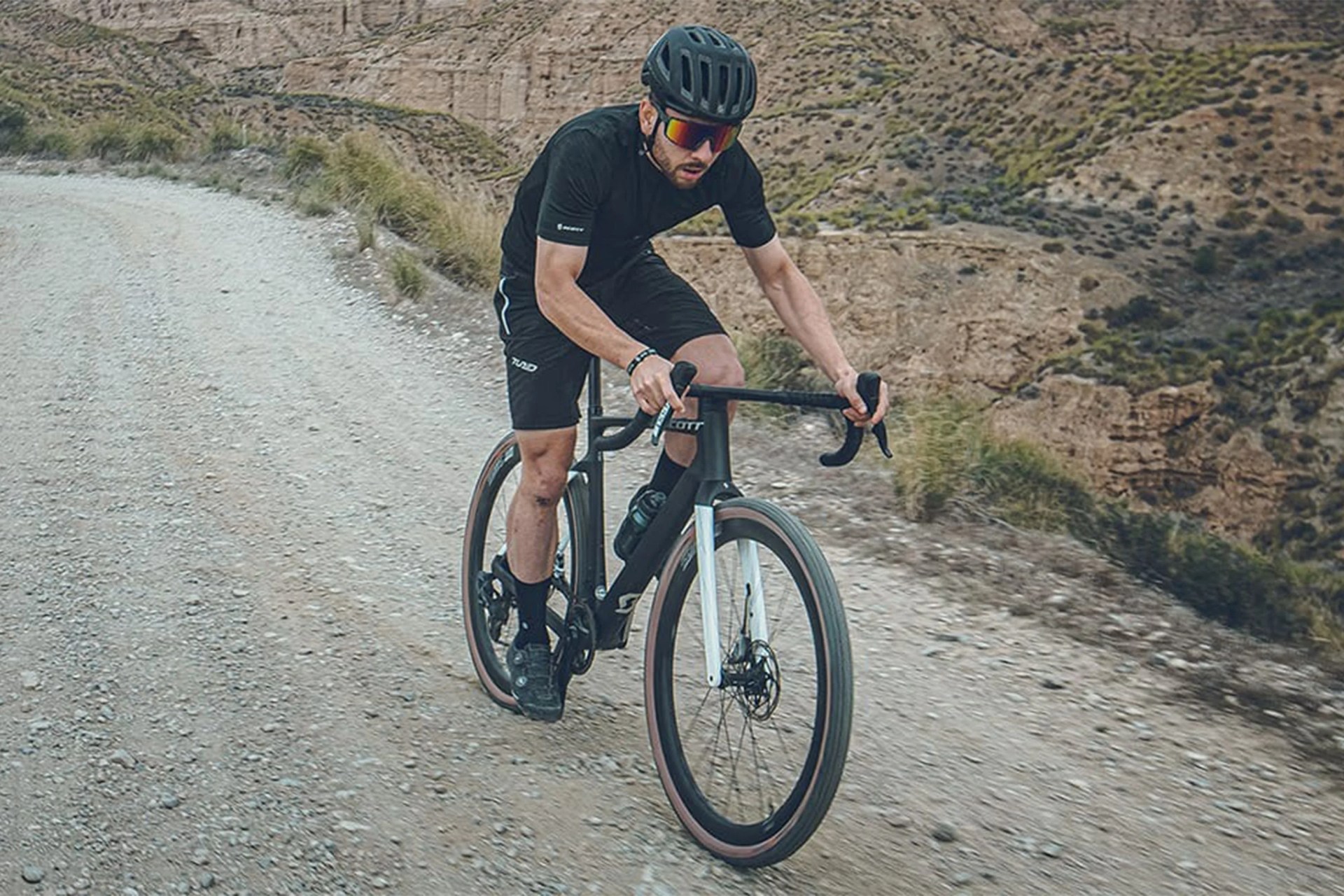 man riding a bike on a gravel road