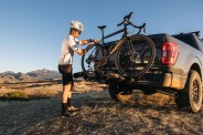 a person putting a bike on the back of a truck
