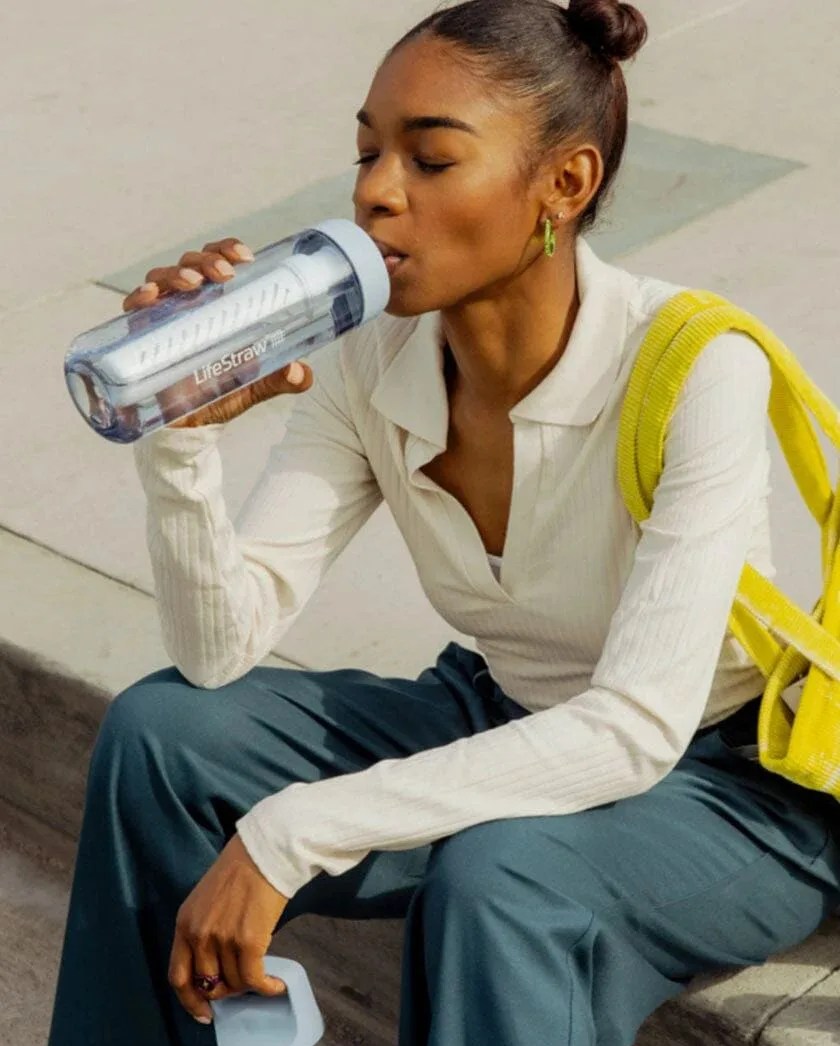 woman sitting drinking out of lifestraw go series 22 oz