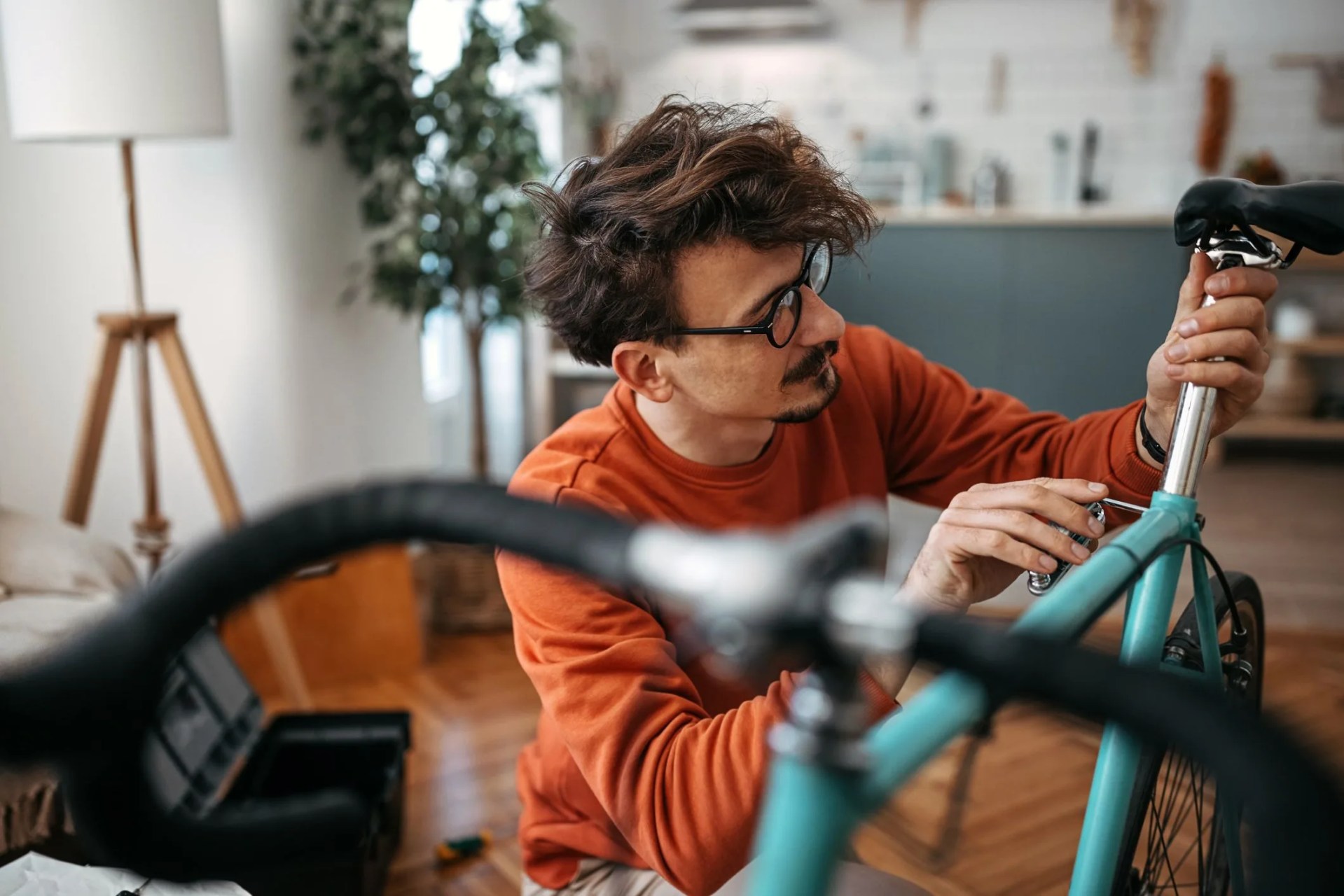 young man adjusting bicycle at home
