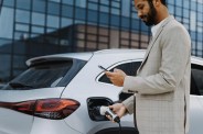 young multiracial businessman charging his car