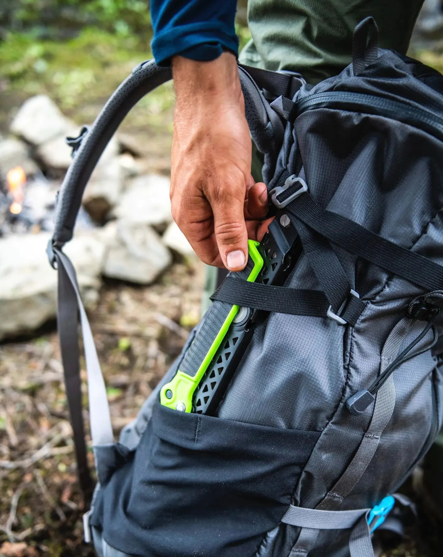man pulling gerber gear freescape camp saw in green out of bag