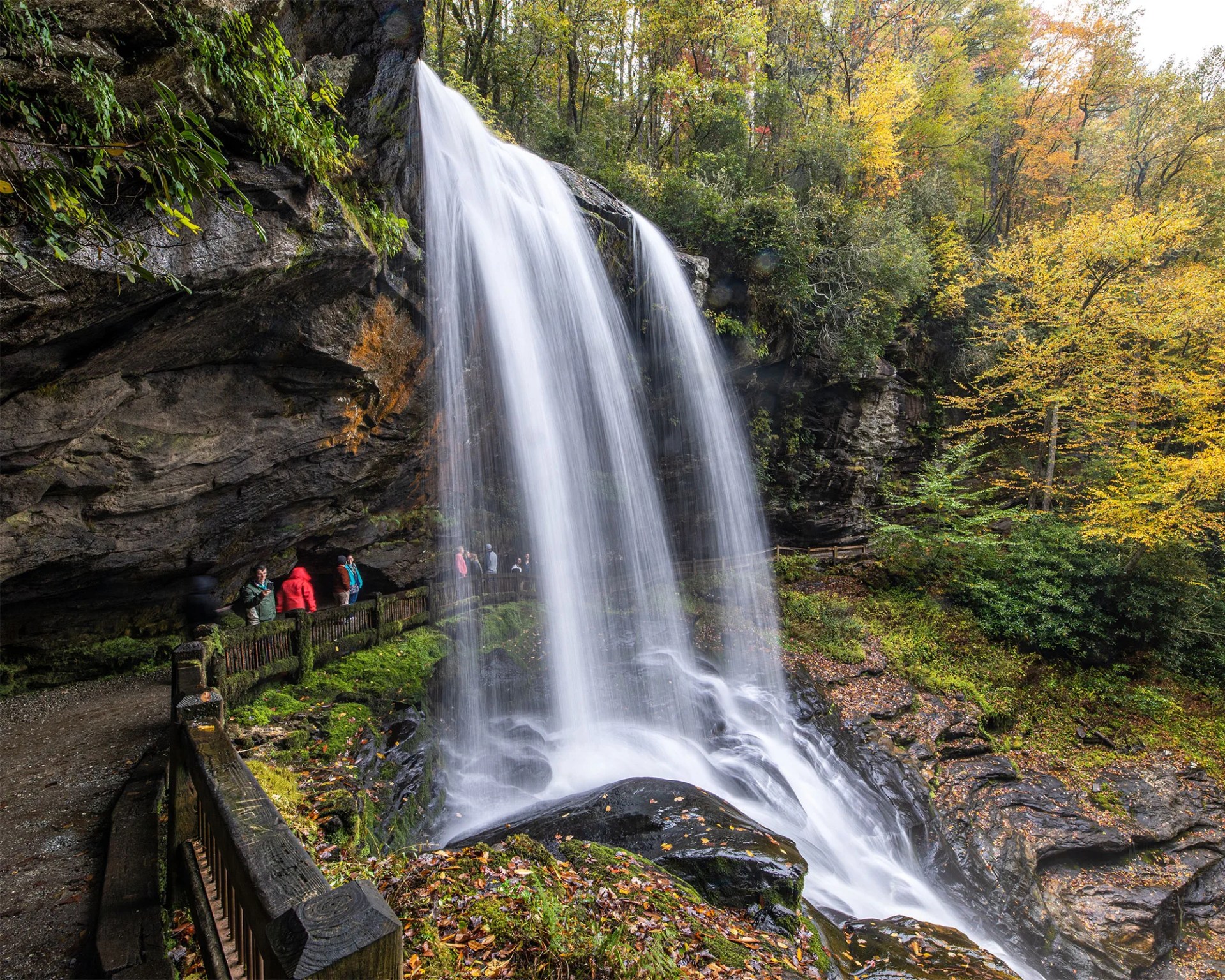 hikers underneath a waterfall