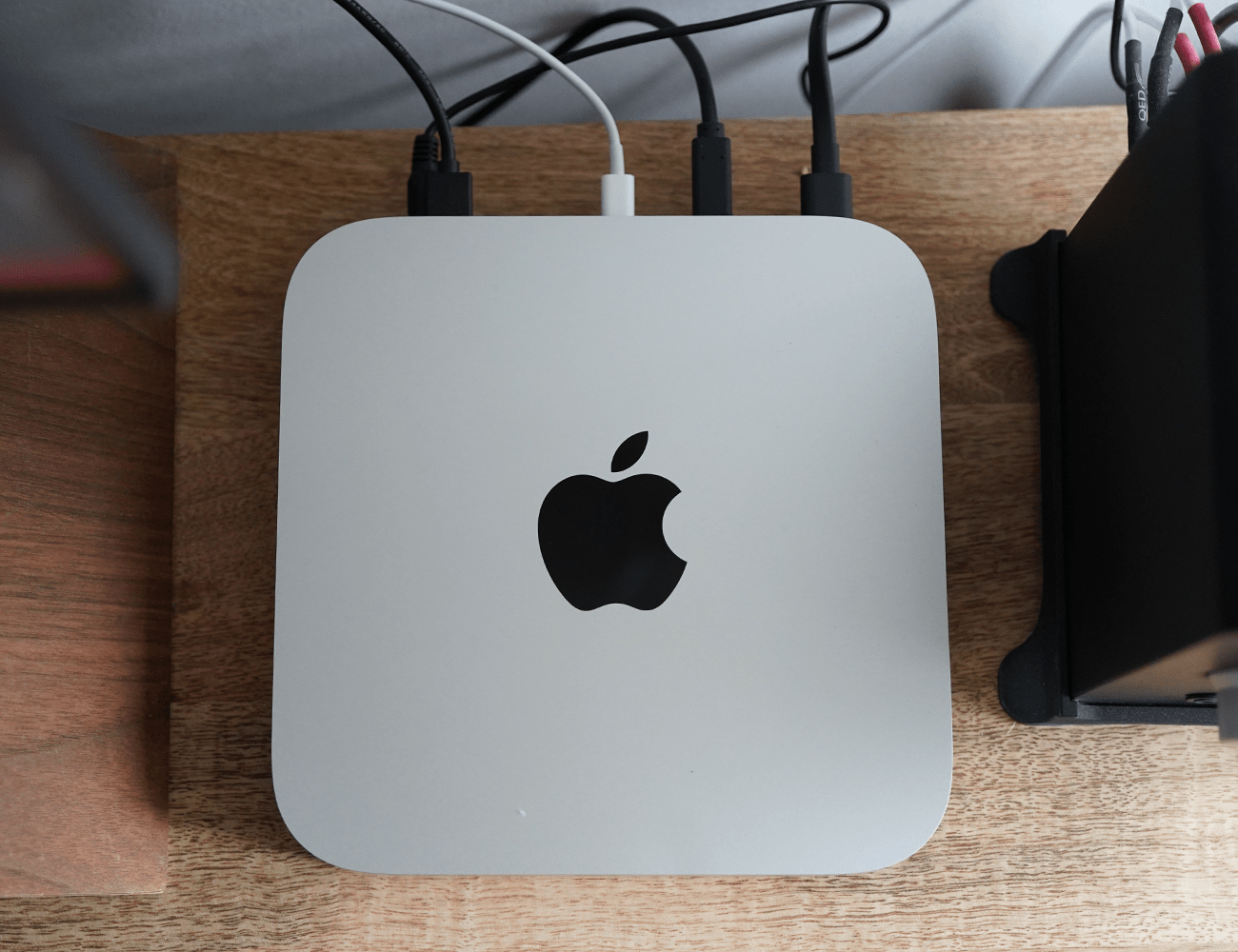 a brown desk with a silver mac mini on it