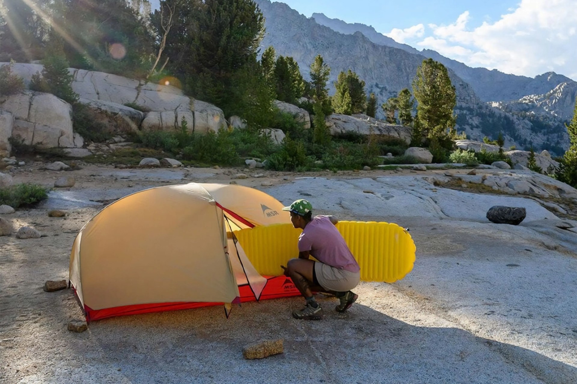 a person putting an air mattress into a tent
