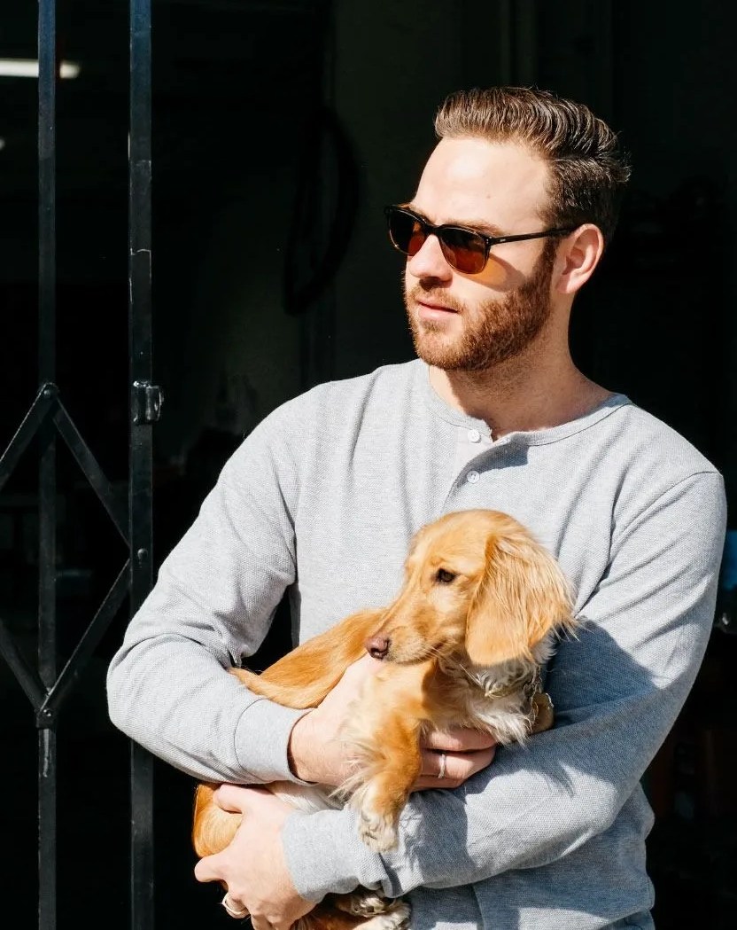 a man wearing sunglasses holding a dog