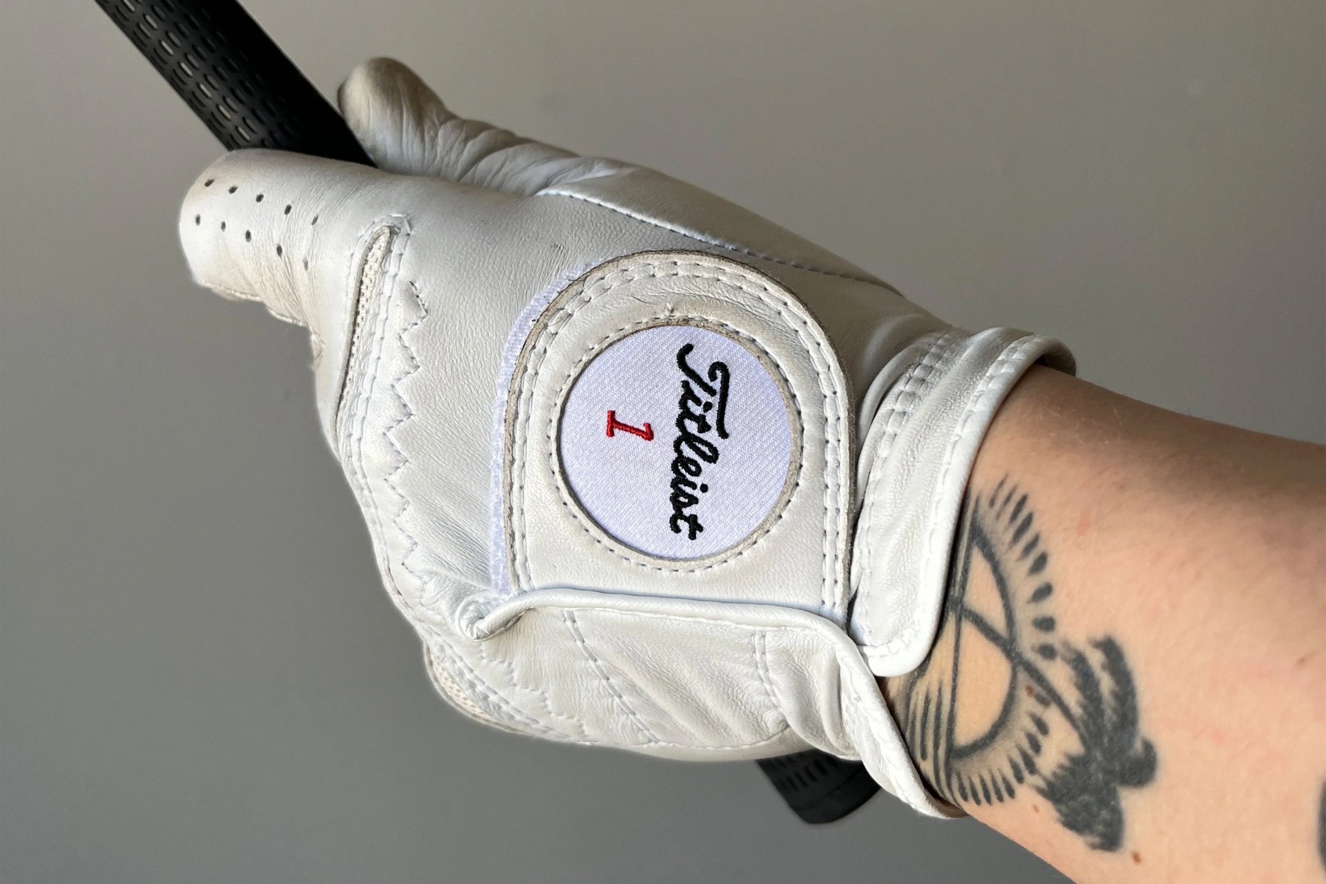 a man wearing a golf glove holding a golf club