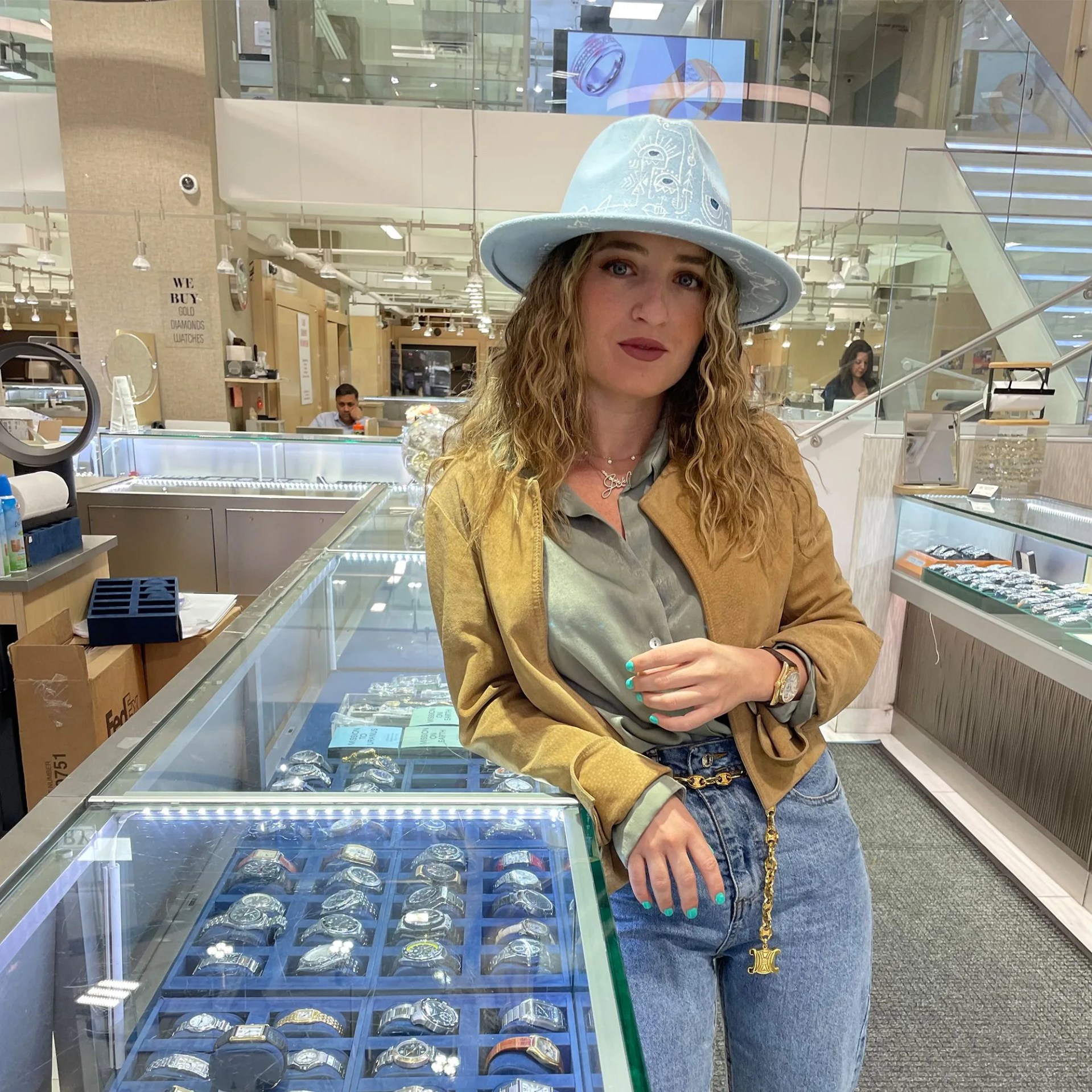 a women leaning against a watch display in a store