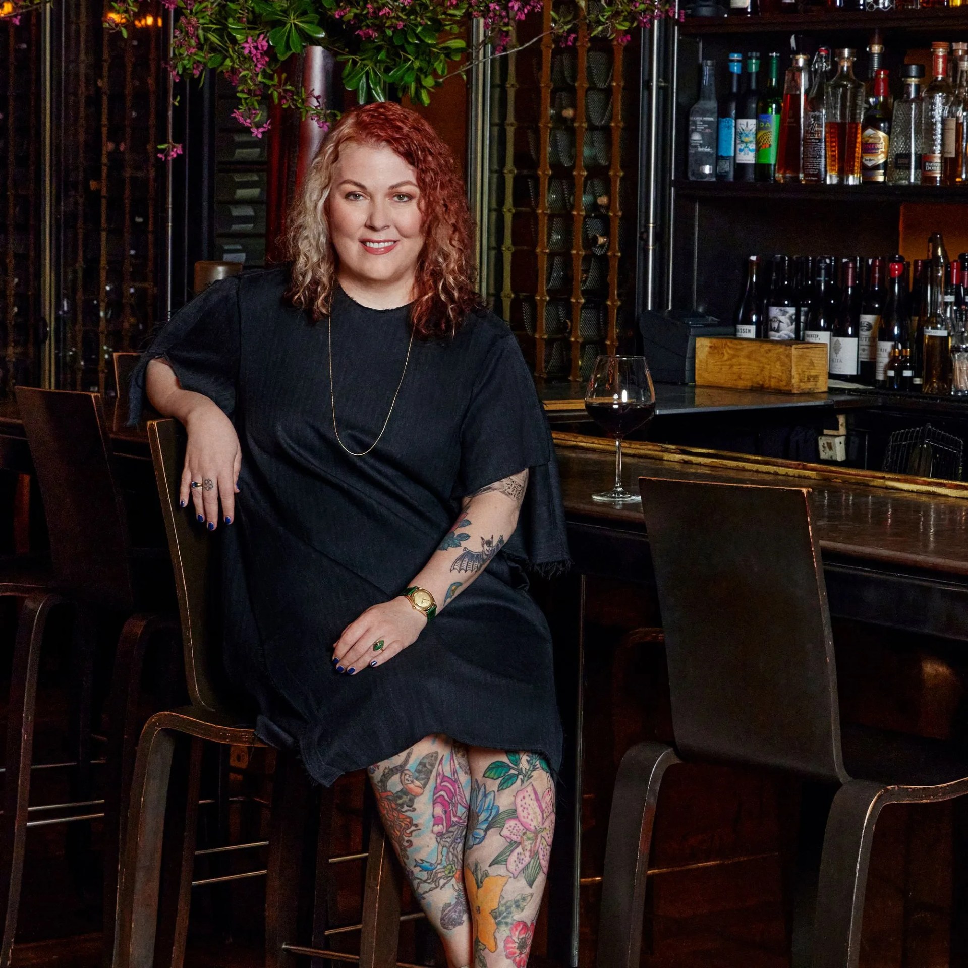 a woman sitting at a bar with a glass of wine