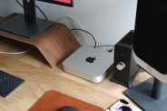 a brown desk with a silver apple mac mini on it