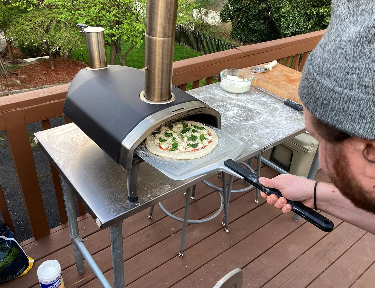 jack putting a pizza into the ooni fyra pizza oven