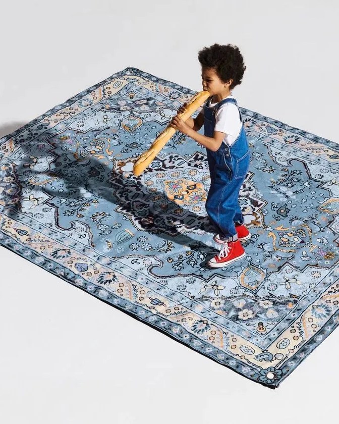 child eating bread standing on fat boy picnic lounge beach blanket
