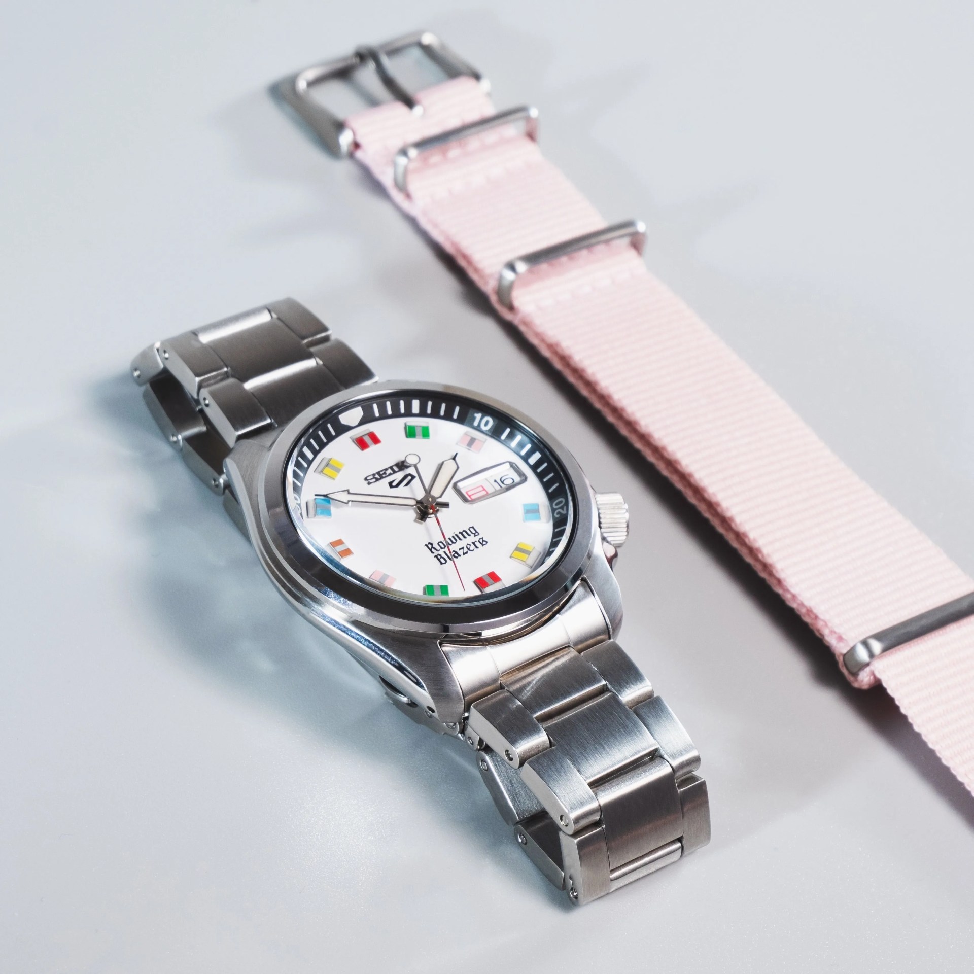 seiko x rowing blazers collab watch on steel bracelet next to colorful nato strap