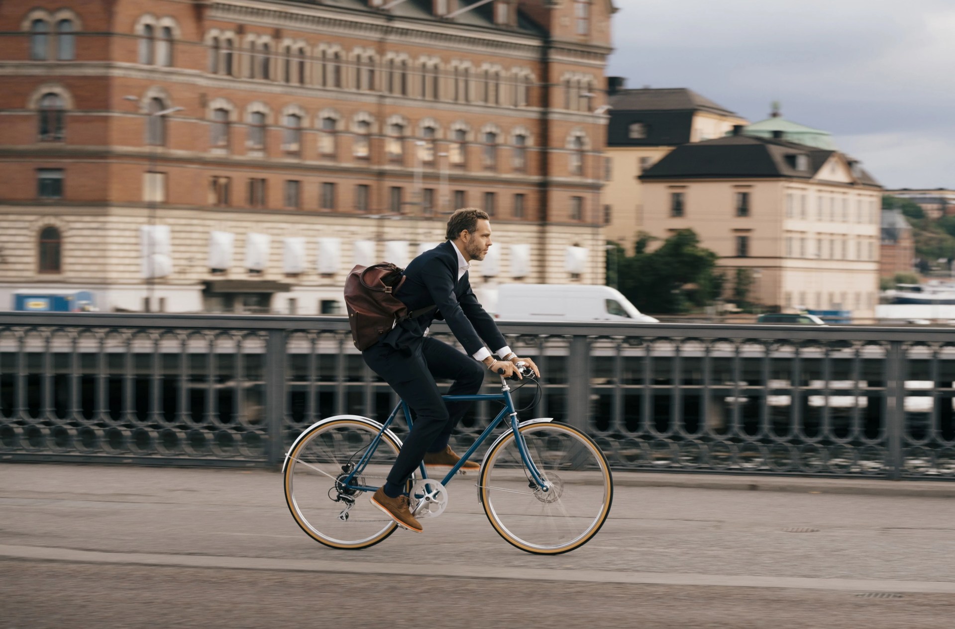 side view of businessman riding bicycle on street in city