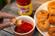 a chicken nugget being dipped in hot sauce