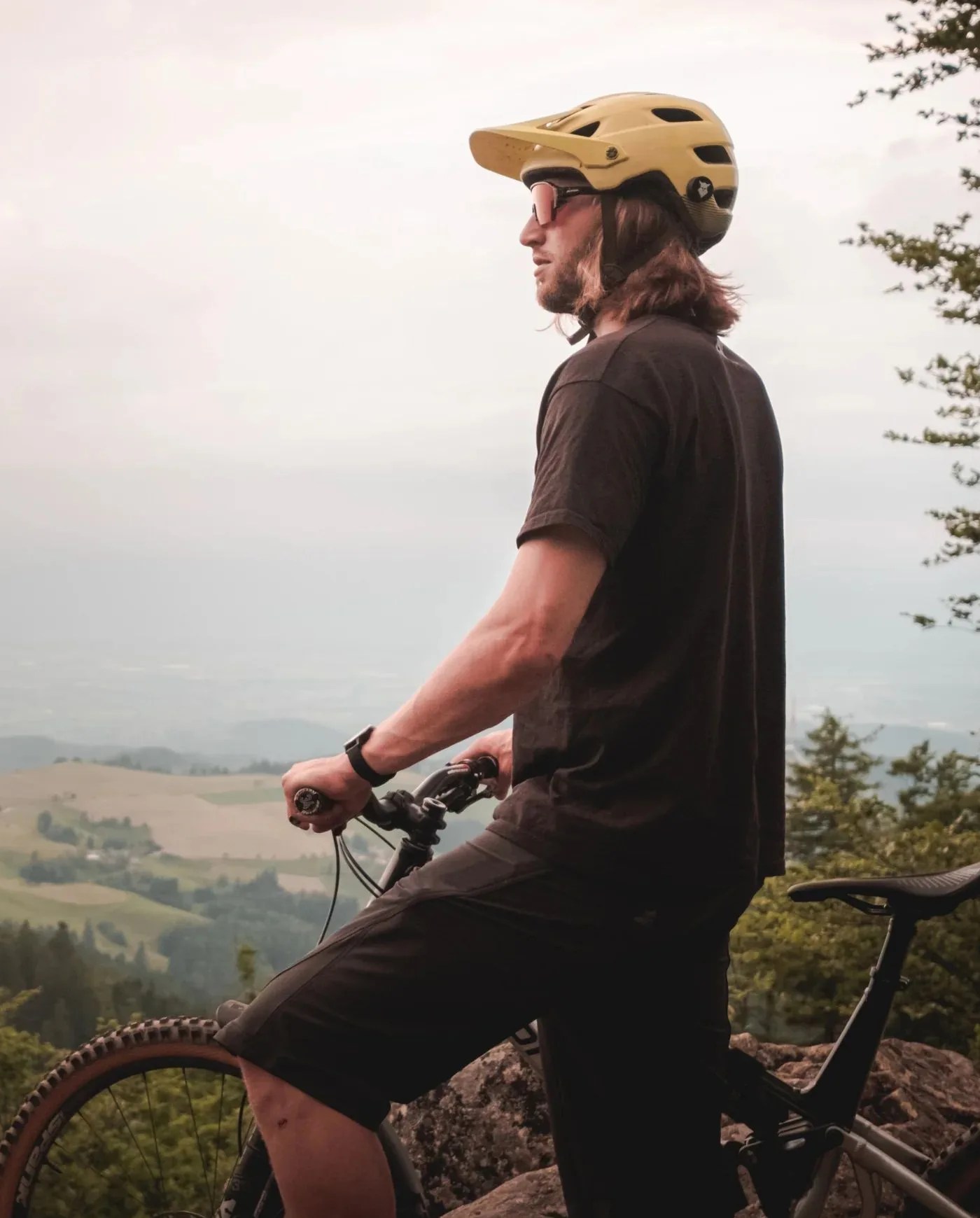man wearing tocsen helmet crash sensor standing next to bike