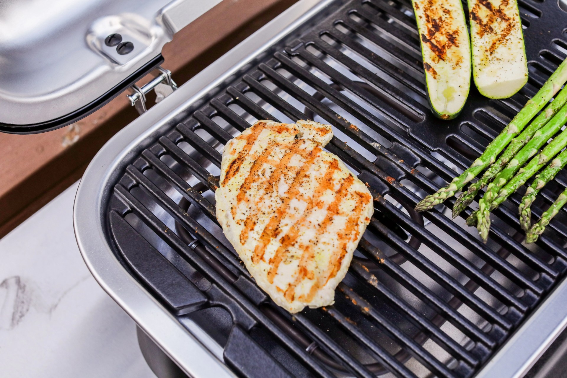 chicken and veggies cooking on a grill