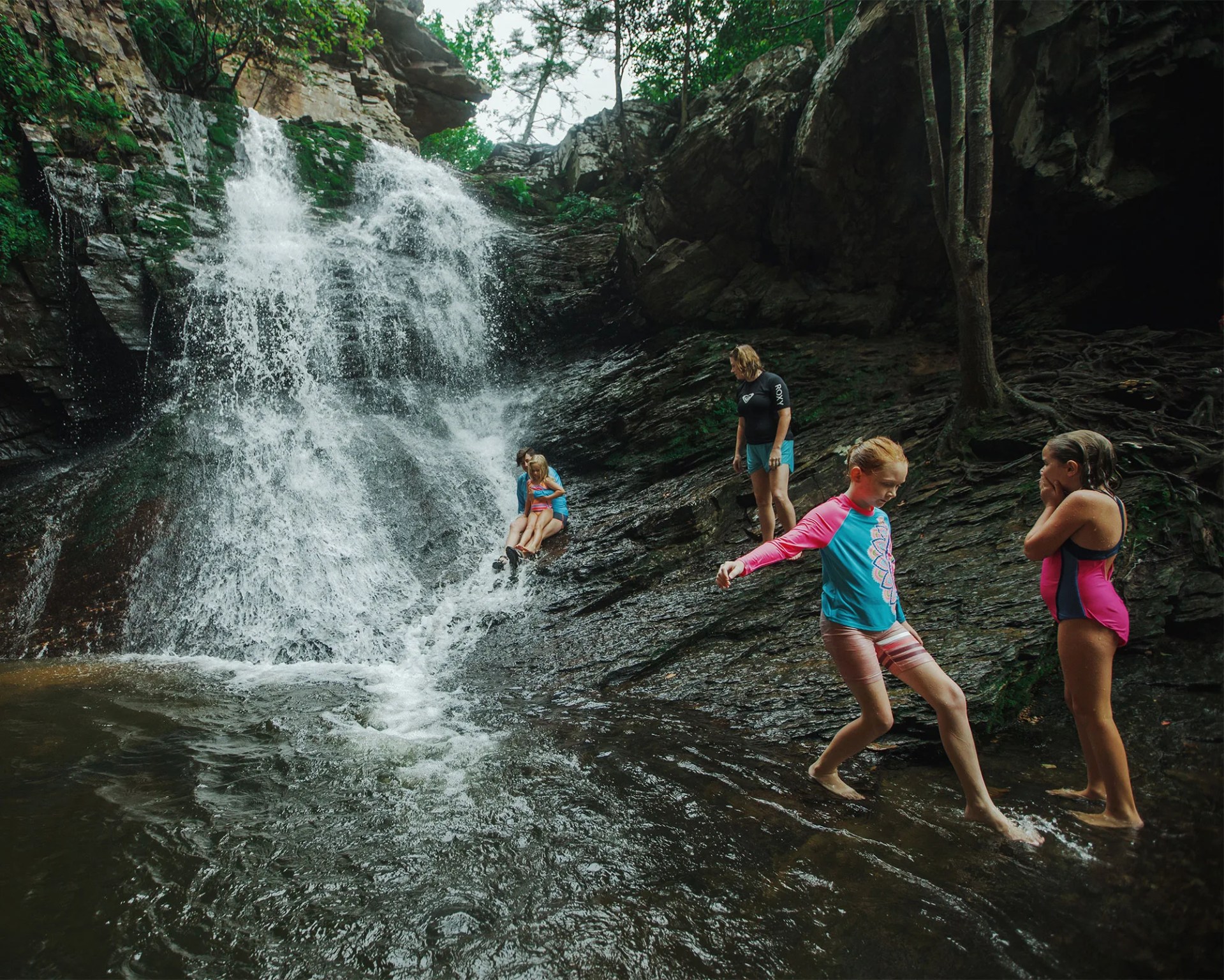 a group of children playing by a waterfall