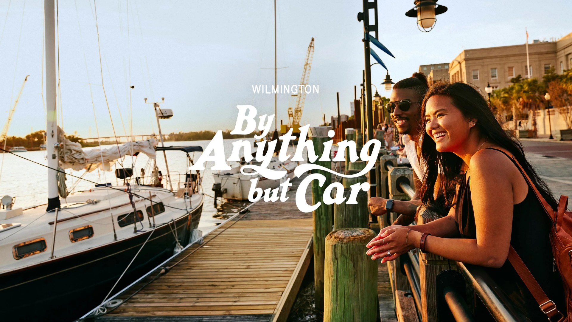 By Anything But Car Wilmington a woman and man leaning against a fence along the pier