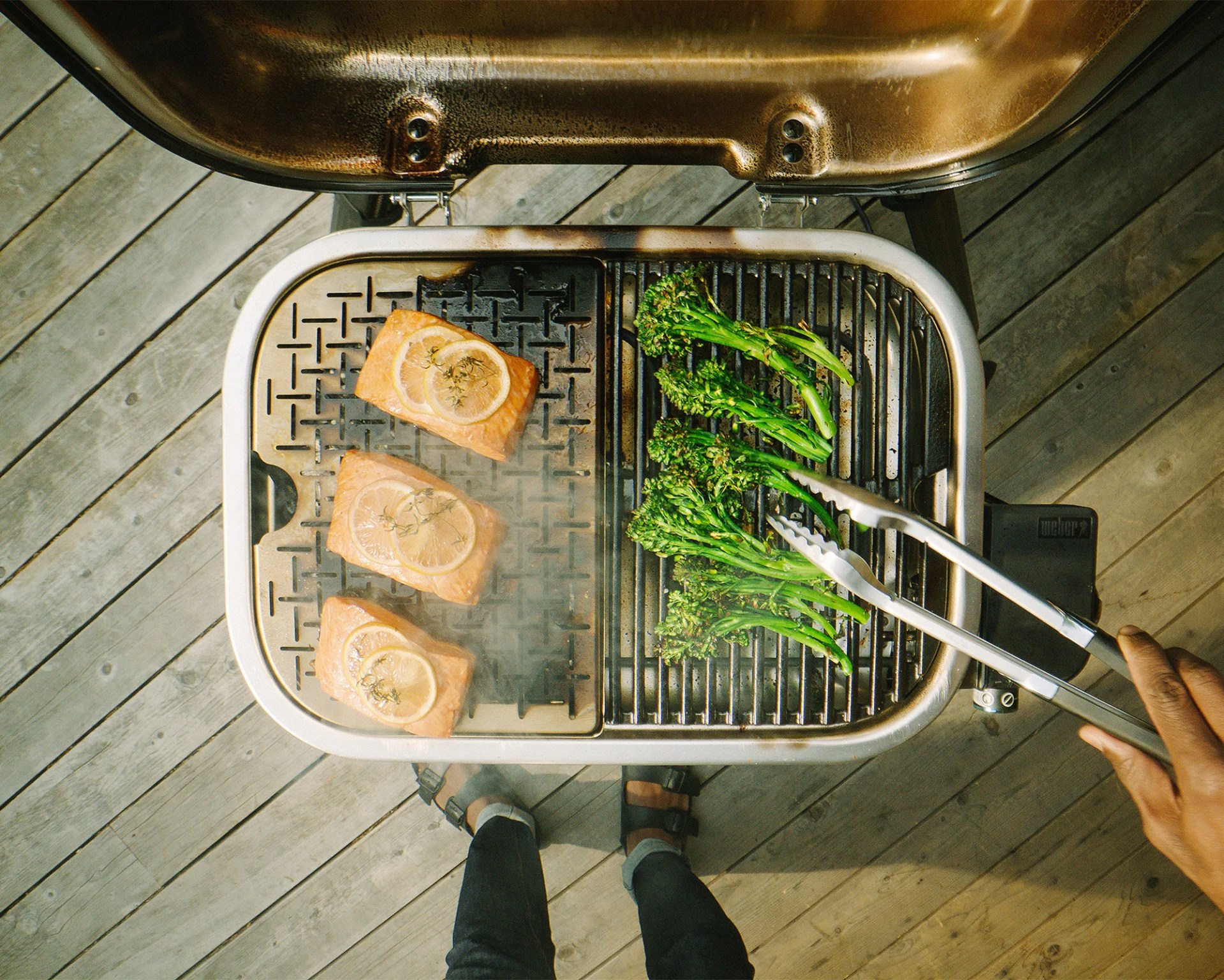 man grilling salmon and asparagus with weber grill
