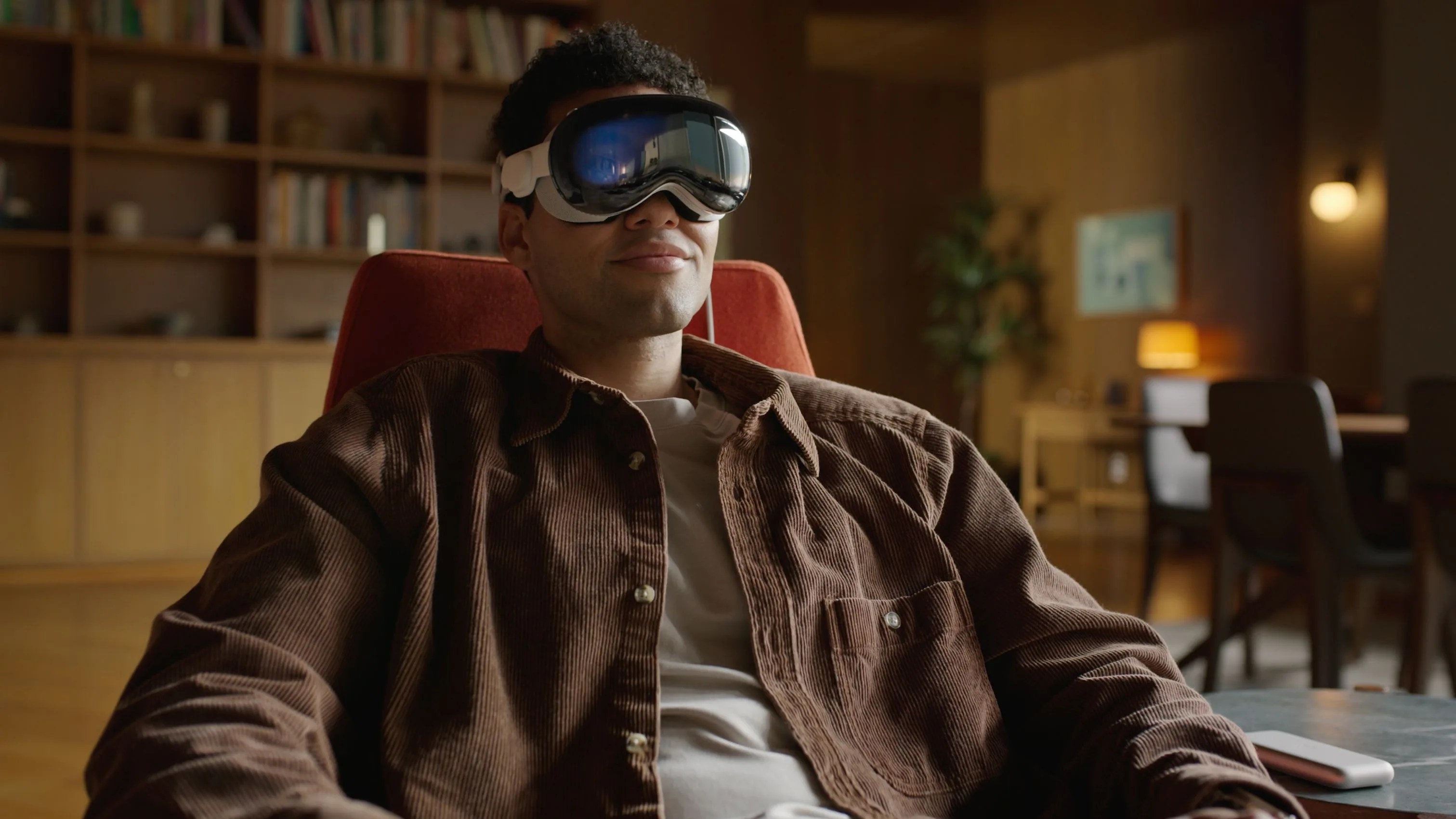 a man sitting in a chair using apple vision pro goggles