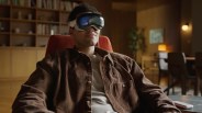 a man sitting in a chair using apple vision pro goggles