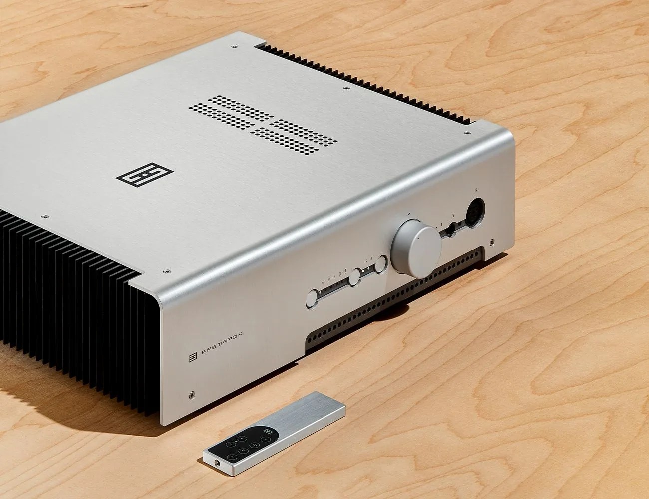 an amplifier and remote sitting on a wooden table