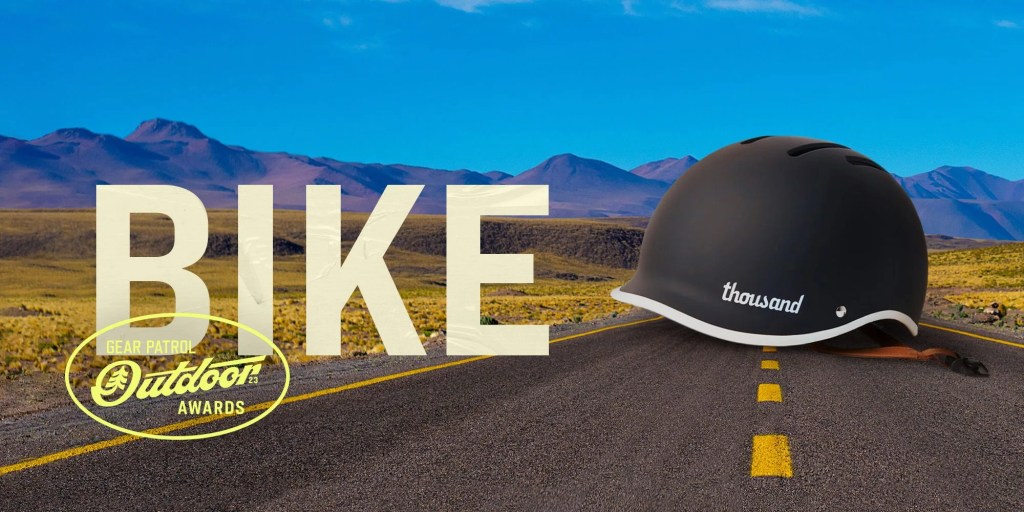 a helmet on a road landscape with a bike headline and outdoor badge icon