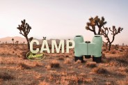 binoculars in a desert landscape with a camp headline and outdoor badge icon