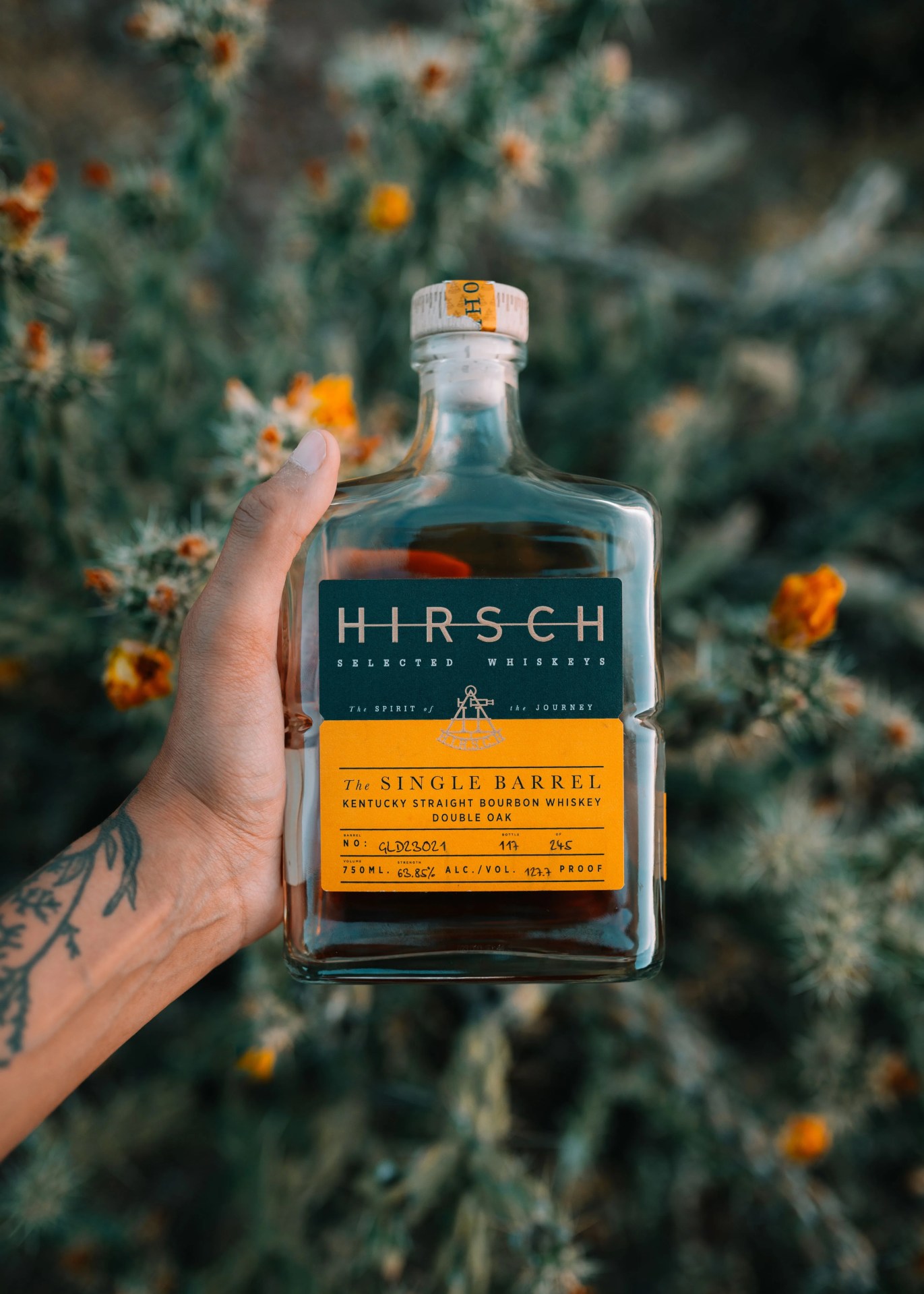 a person holding a bottle of hirsch whiskey