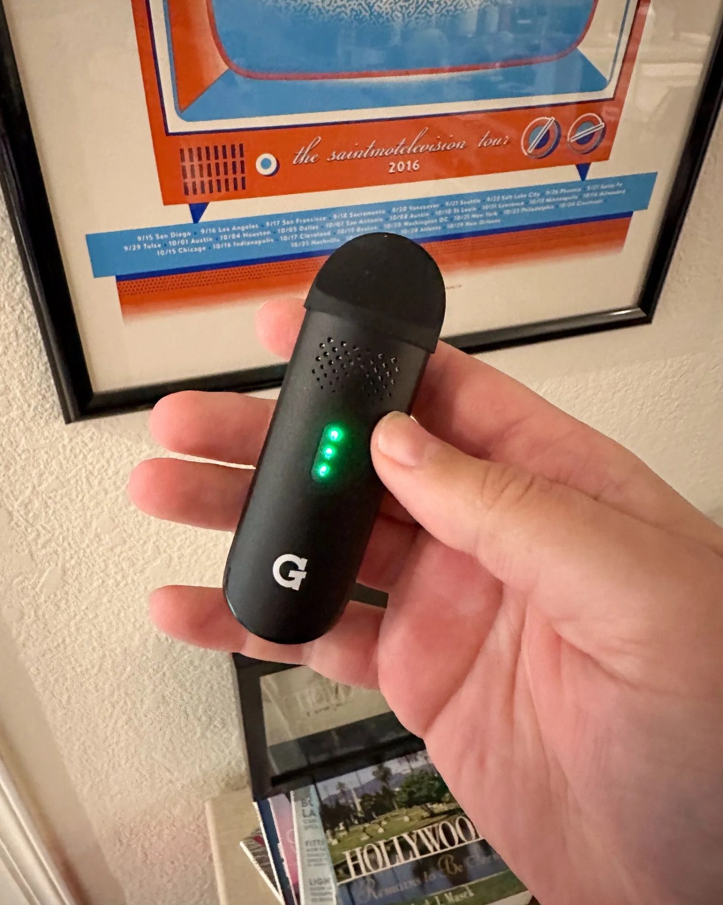 a person holding a g pen vape