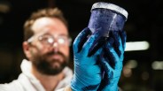 worker looking at indigo dye with blue gloves