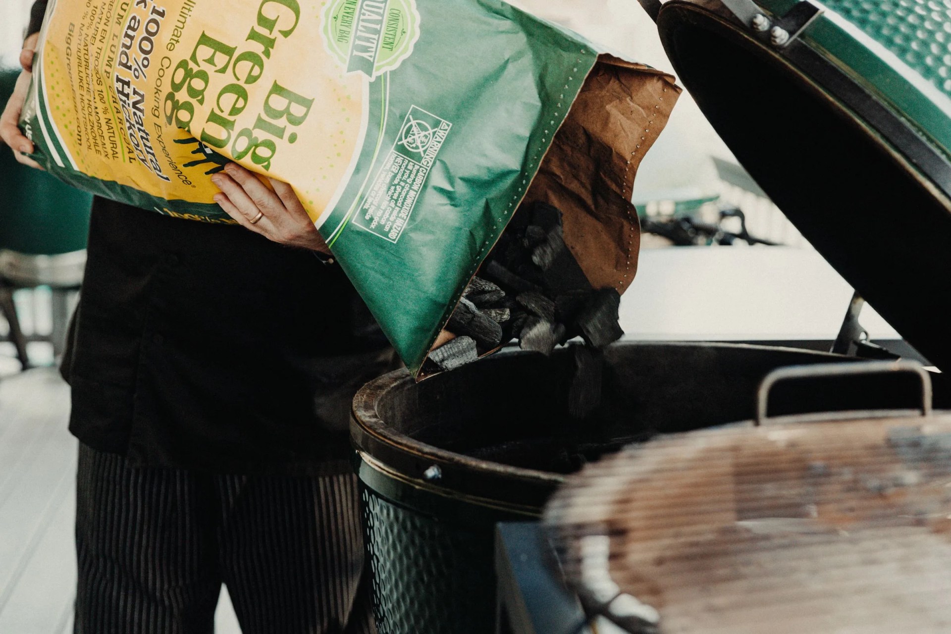 dumping charcoal into a big green egg grill