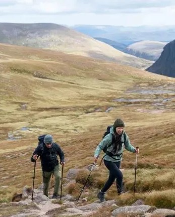 two people hiking in the hills wearing leki trekking pole