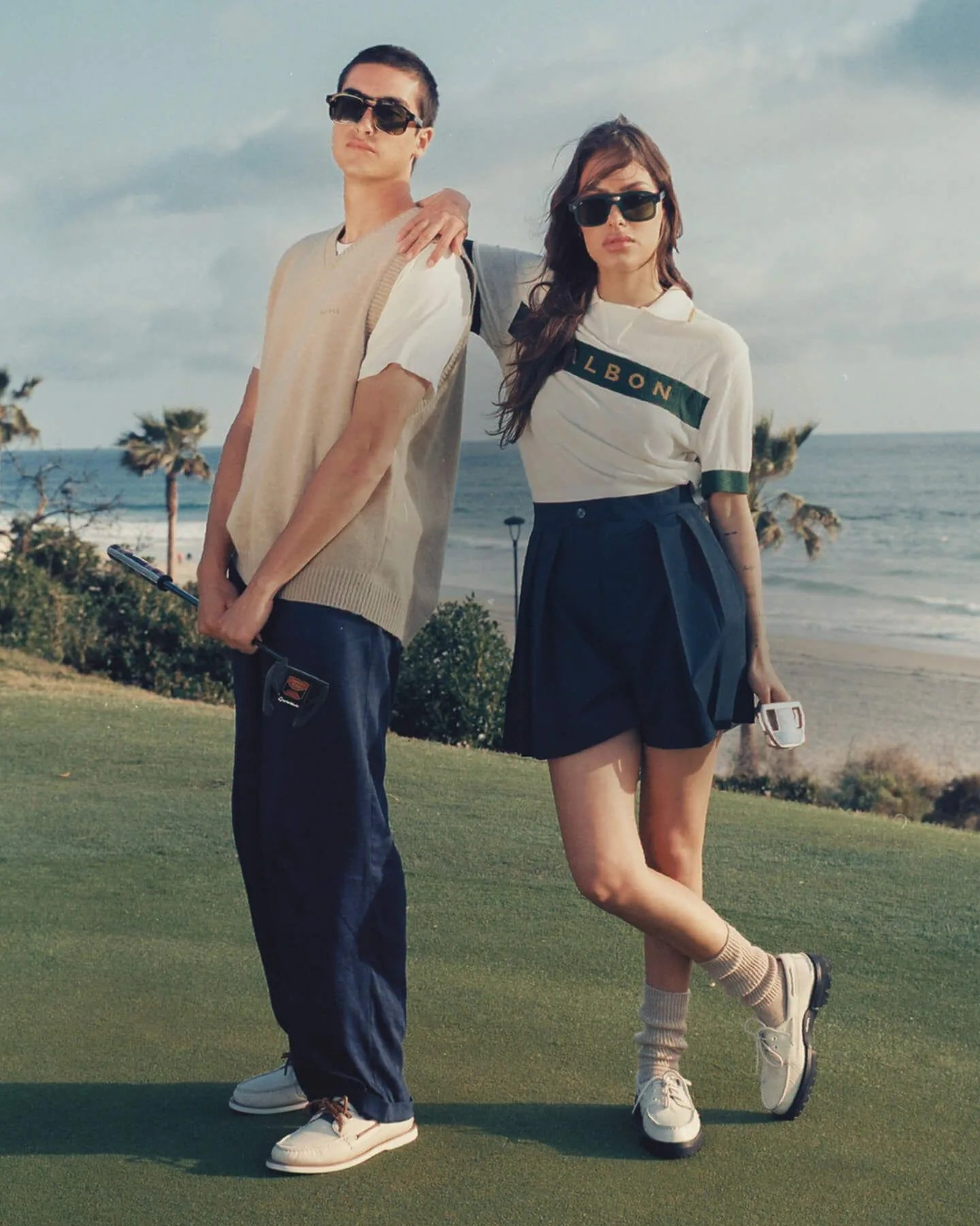 man and woman wearing sperry x malbon golf shoe