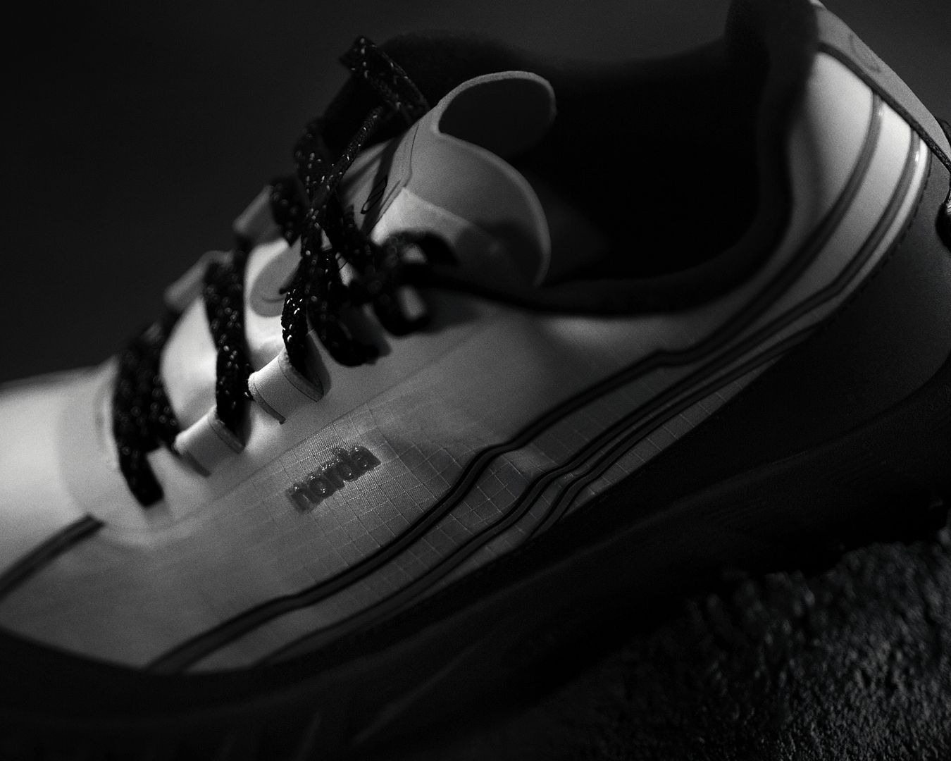 white and black trail running shoe on black background