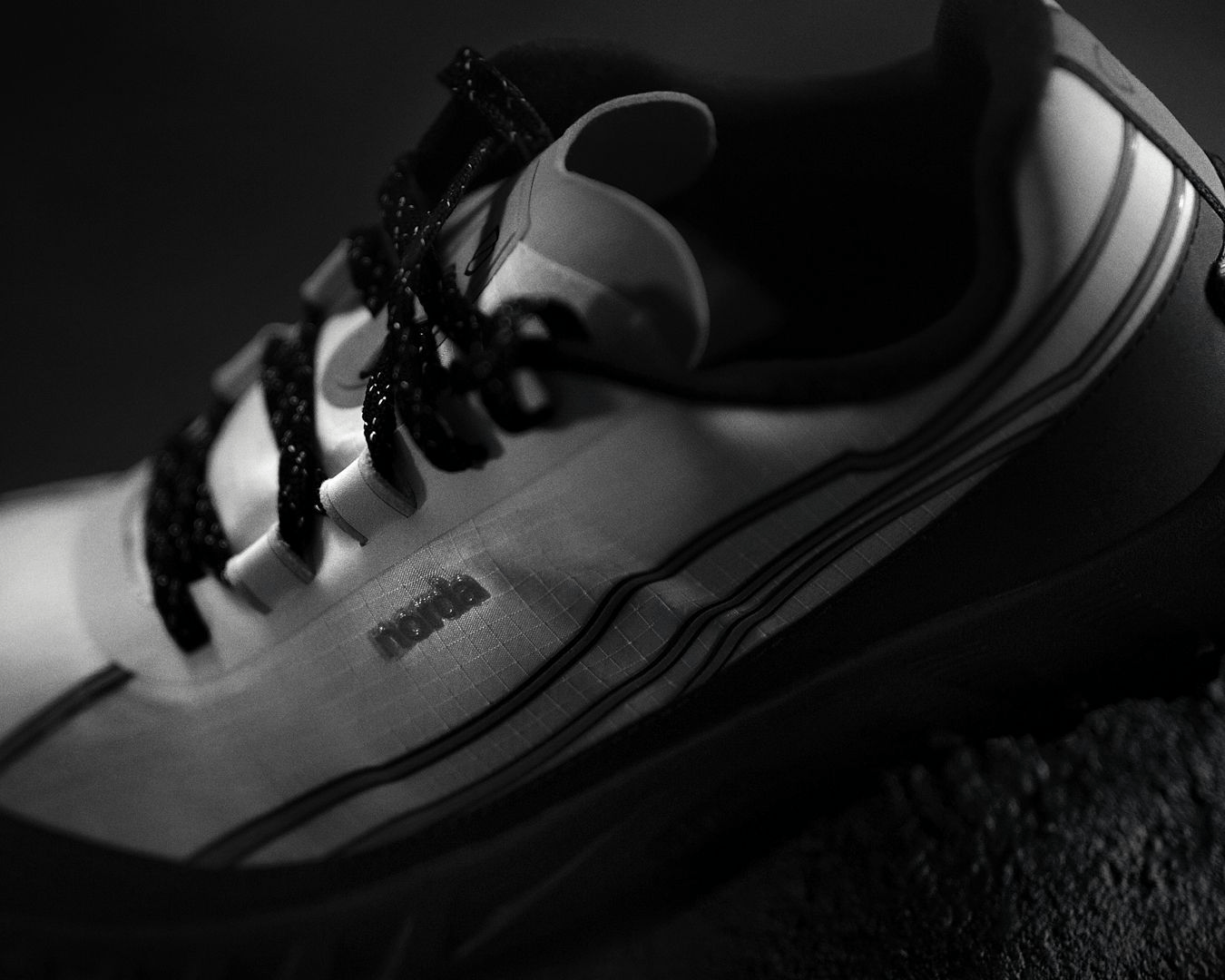 white and black trail running shoe on black background