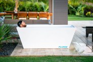 a man taking a cold plunge on an outdoor patio