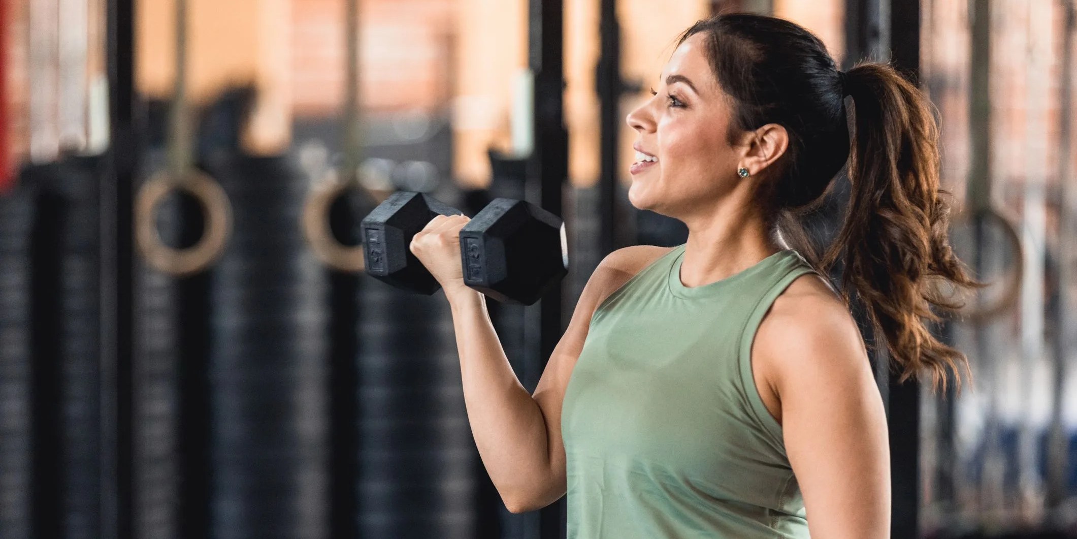 profile view powerful mid adult woman weightlifting at gym
