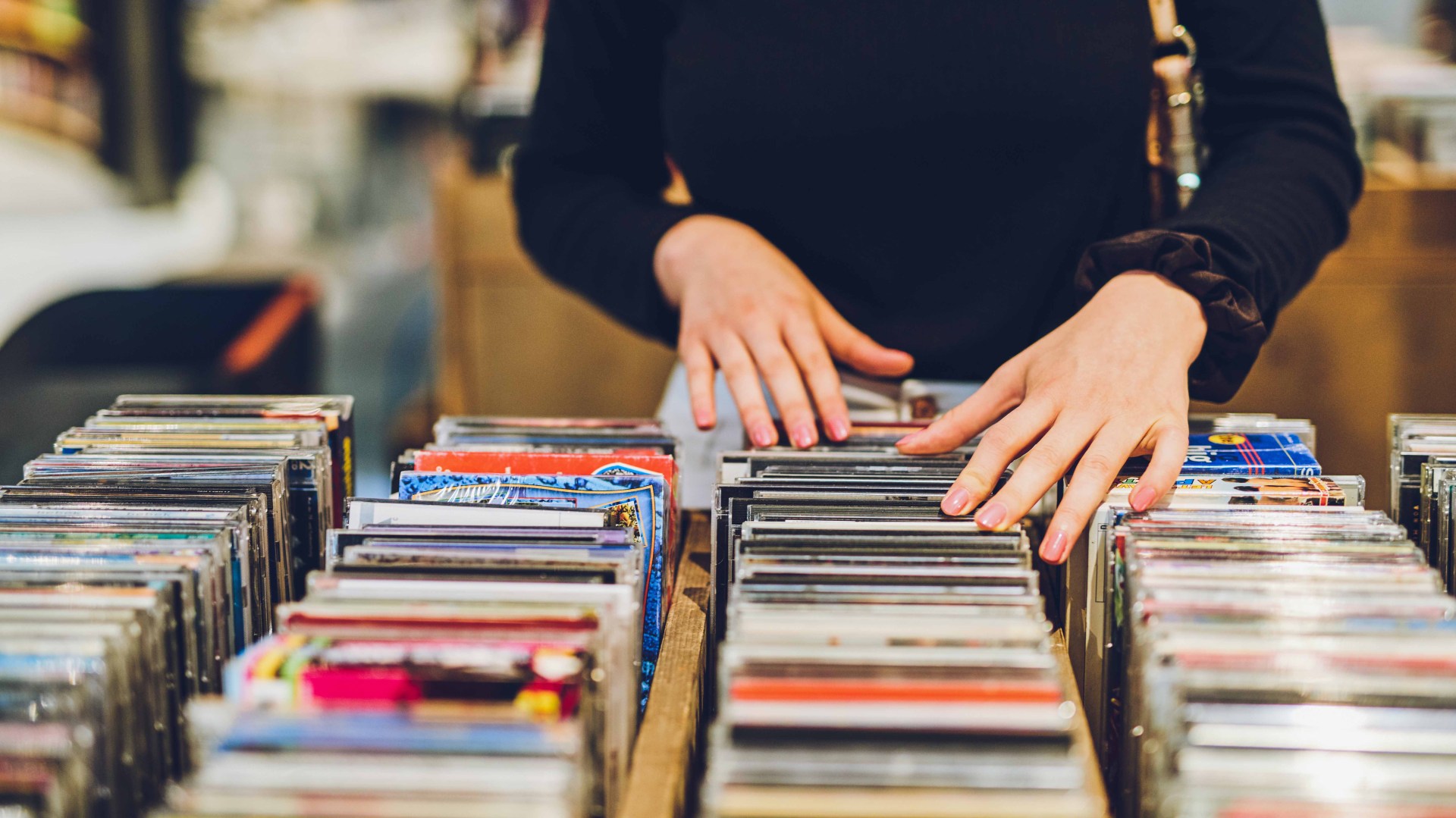 Cropped shot of a young woman shopping for DVDs at a store
