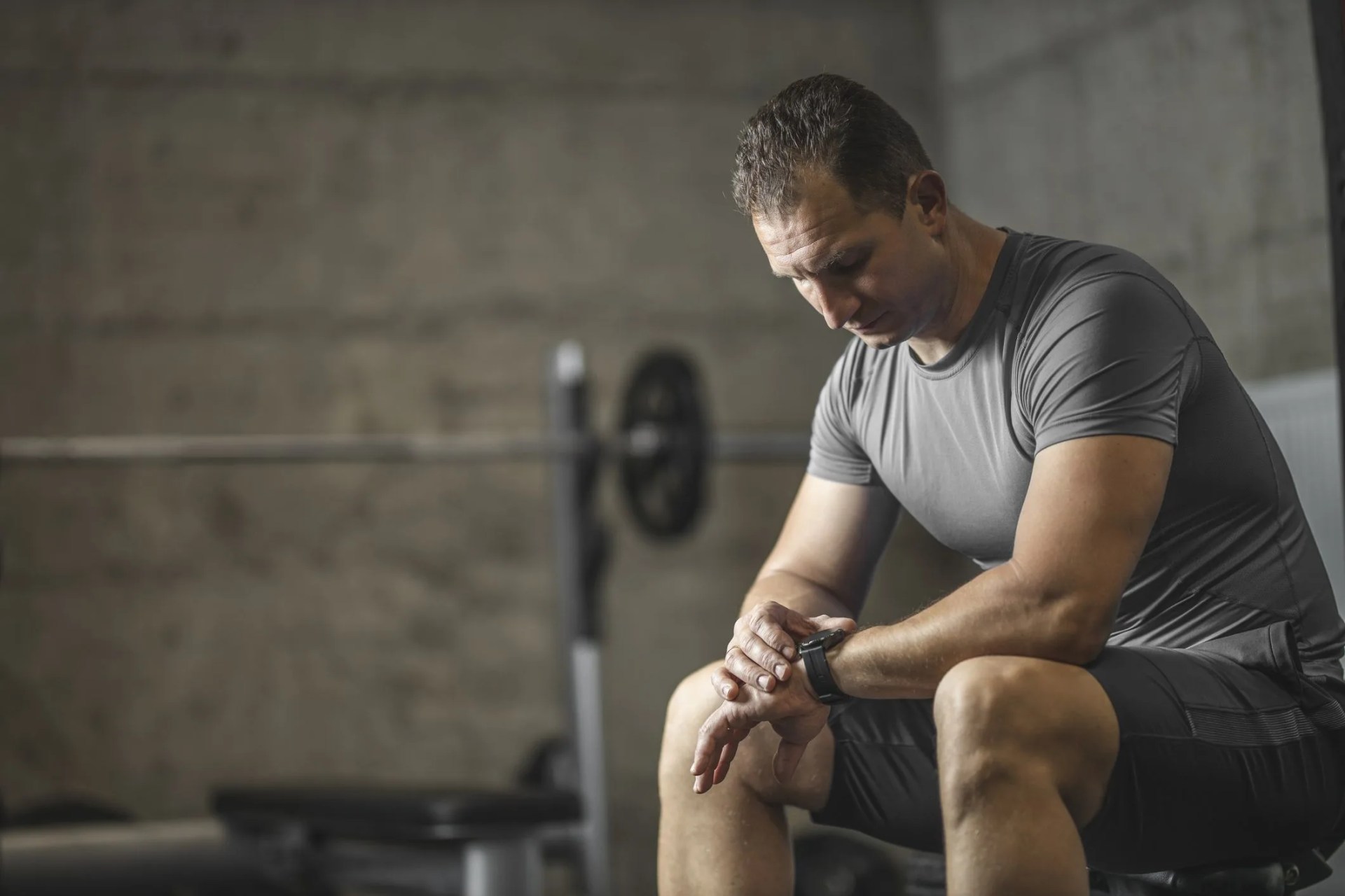 sports man setting his smart watch before training in gym