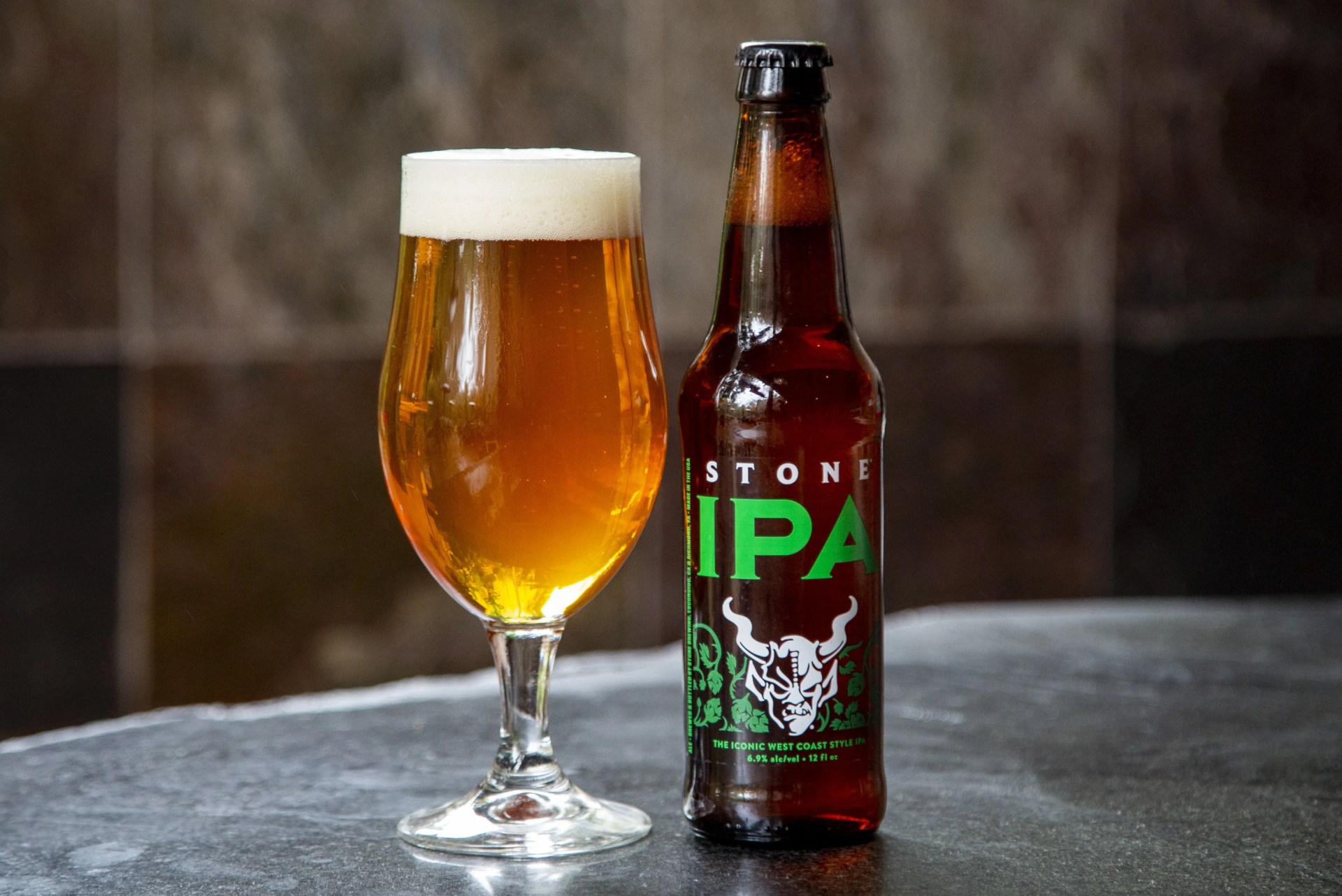a beer bottle sitting next to a beer glass on a counter