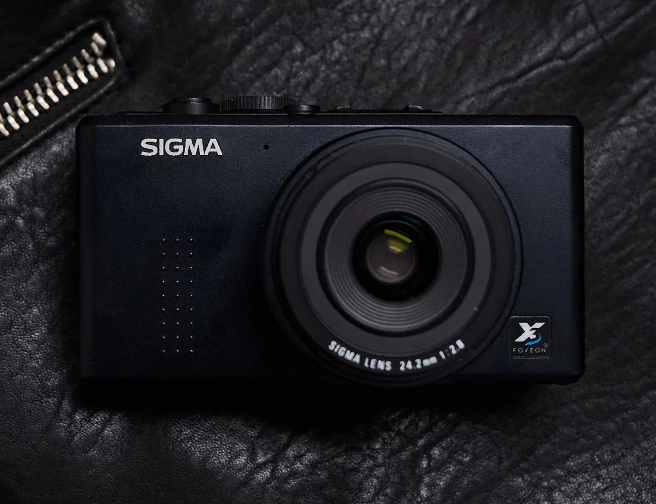 old school camera laying on a black leather jacket