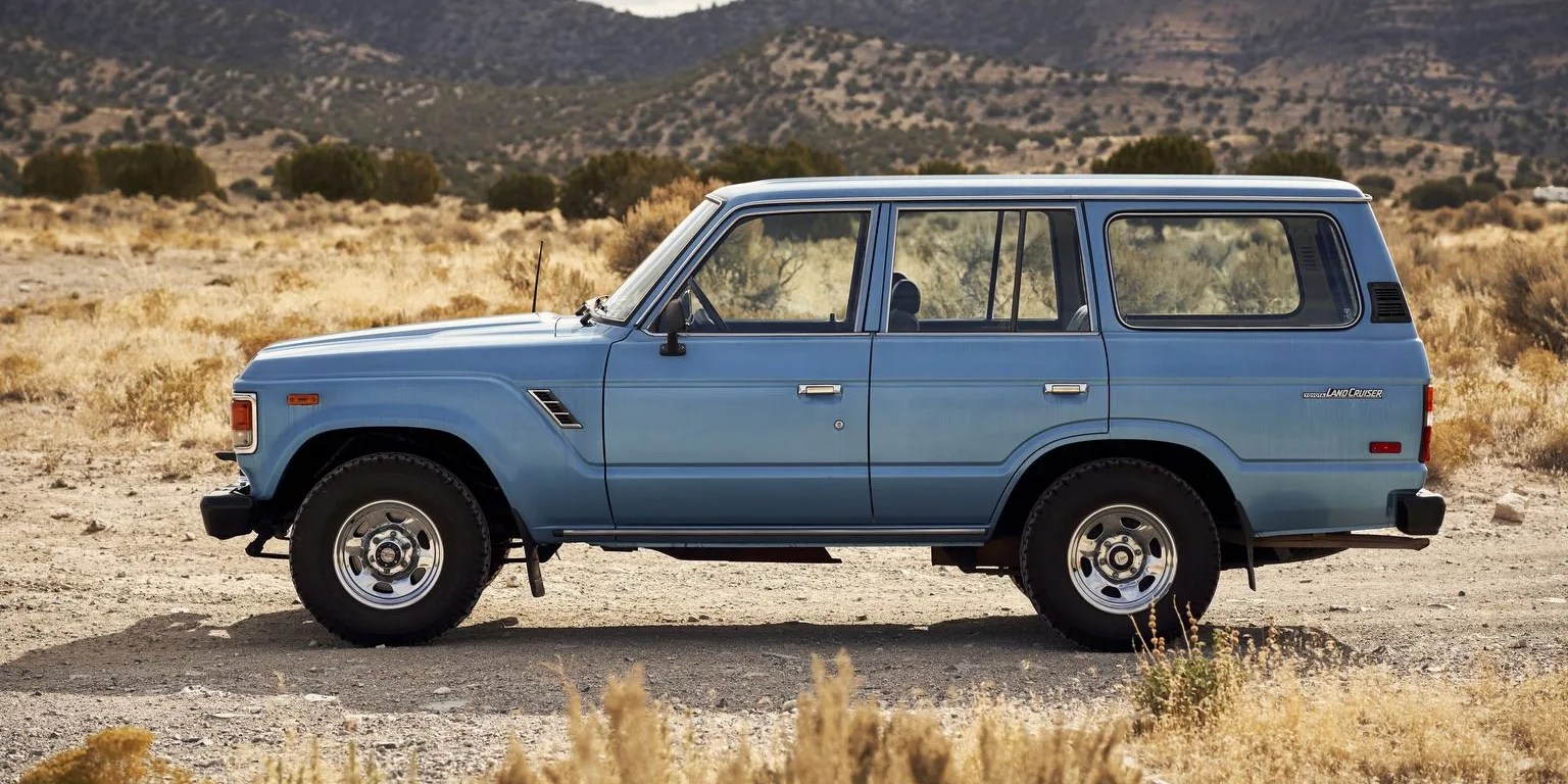blue toyota fj cruiser in front of a mountainous landscape