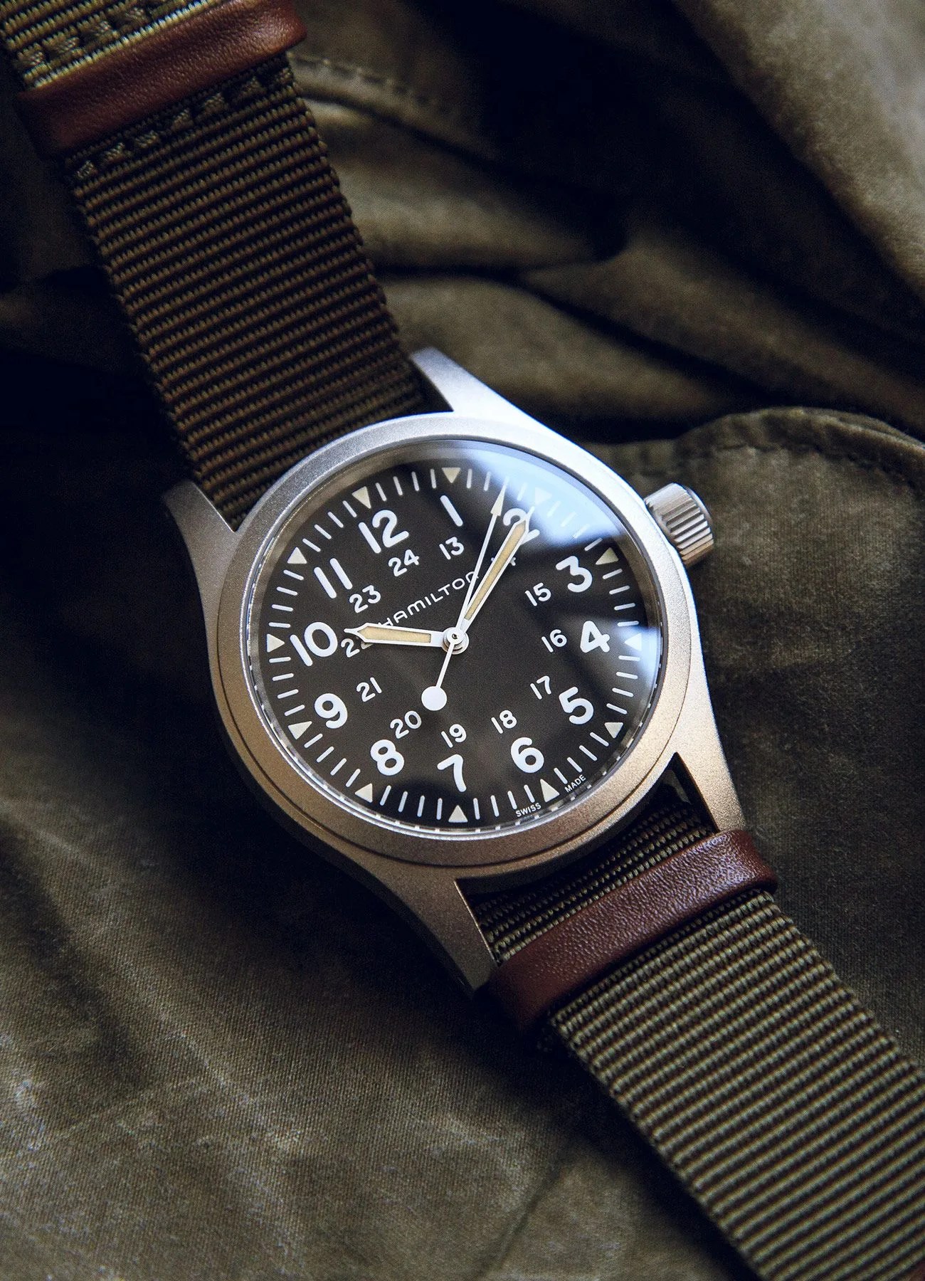 hamilton khaki field watch on green waxed cotton background