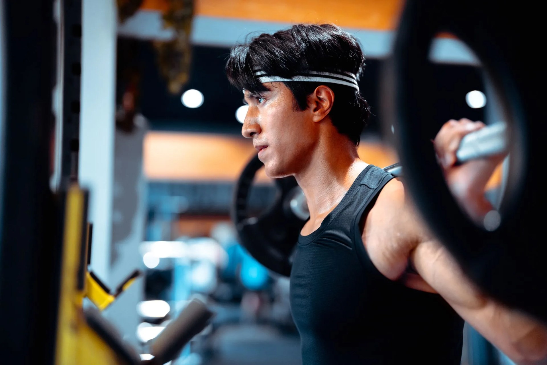 athletic man doing weight lifting at gym health and fitness concept