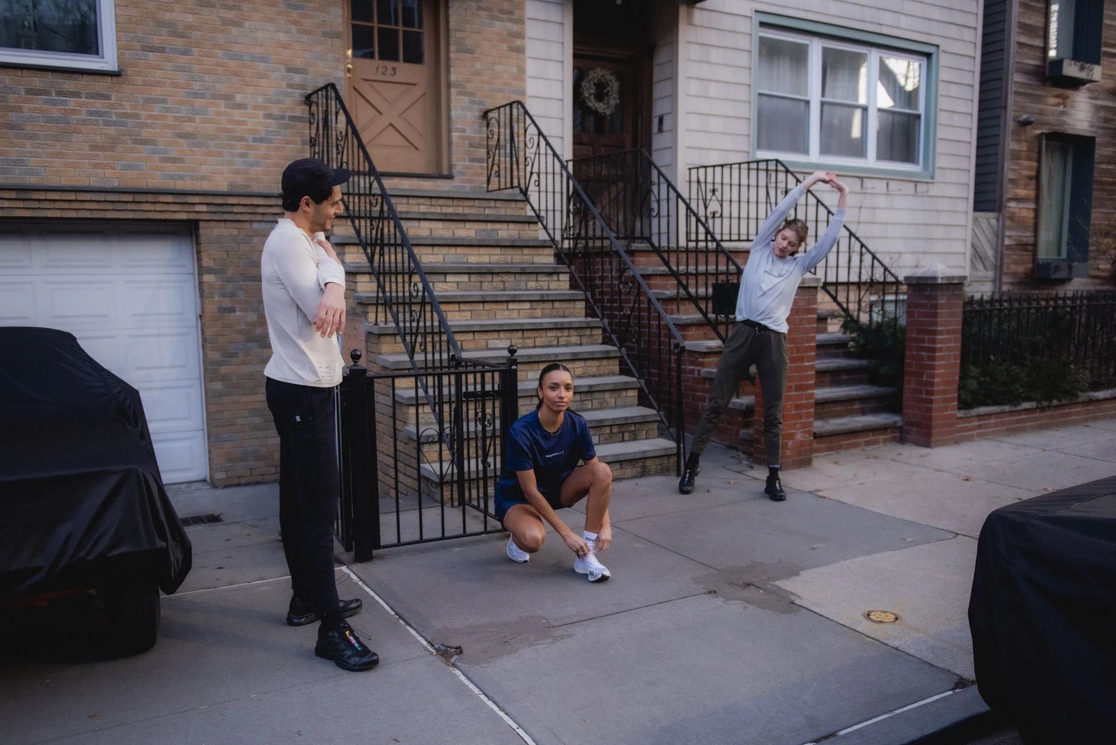 three people stretching outside of a stoop